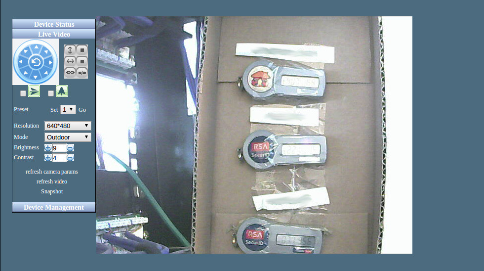 screenshot of a webcam pointing at a box with three hardware TOTP tokens taped to it and the box taped to a sever rack