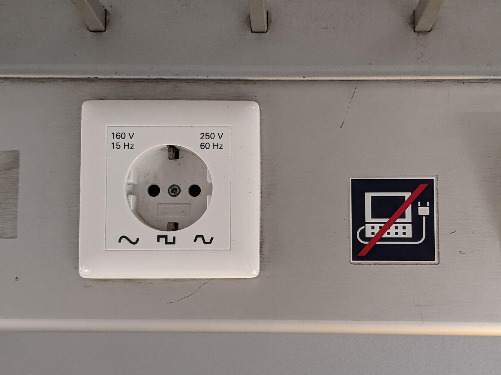 outlet on a train with a "No Computer" sticker that isn't quite a laptop. the power rating is 15 - 60 Hz, 160 - 250V, and either sine square or trapezoid wave.