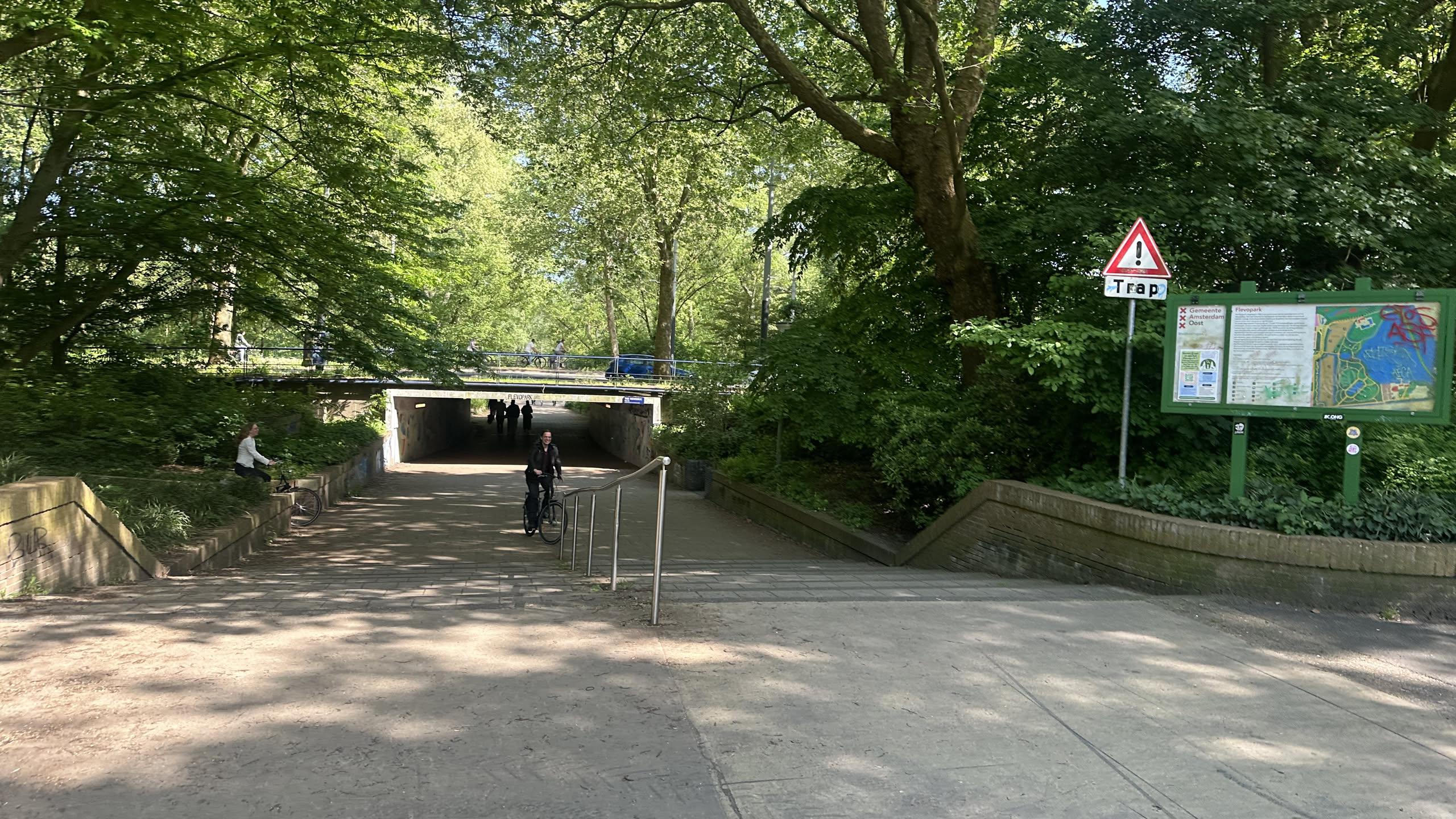 stairs leading into a park with a warning sign that says TRAP!, which means stairs in Dutch.