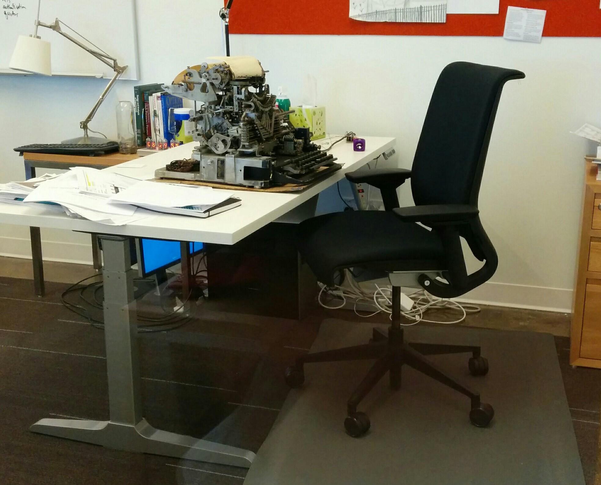 modern office with an uncovered 1930s teletype sitting on the desk instead of the computer