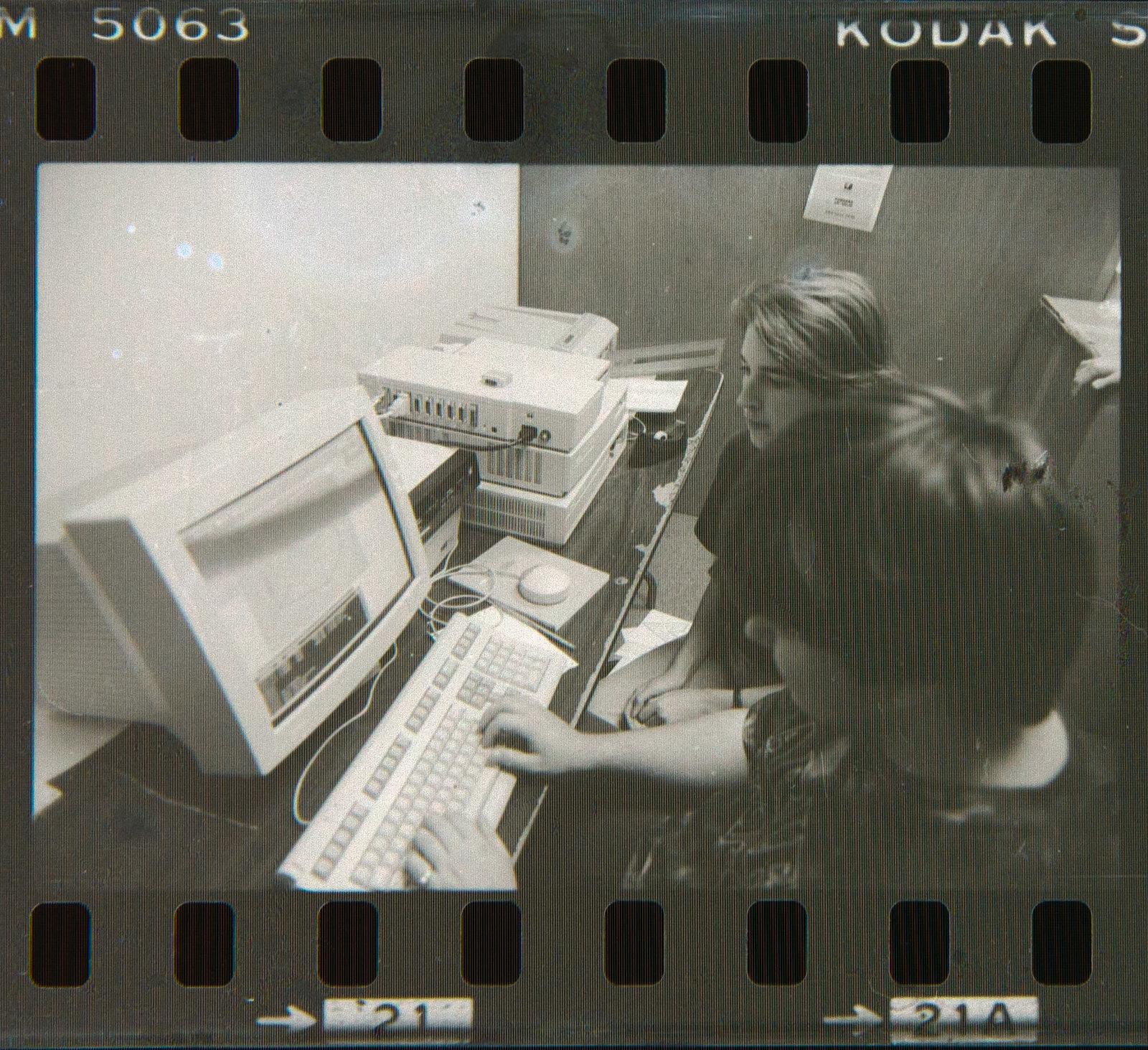 two people sitting at an ancient Ultrix computer with a big CRT and a circular mouse
